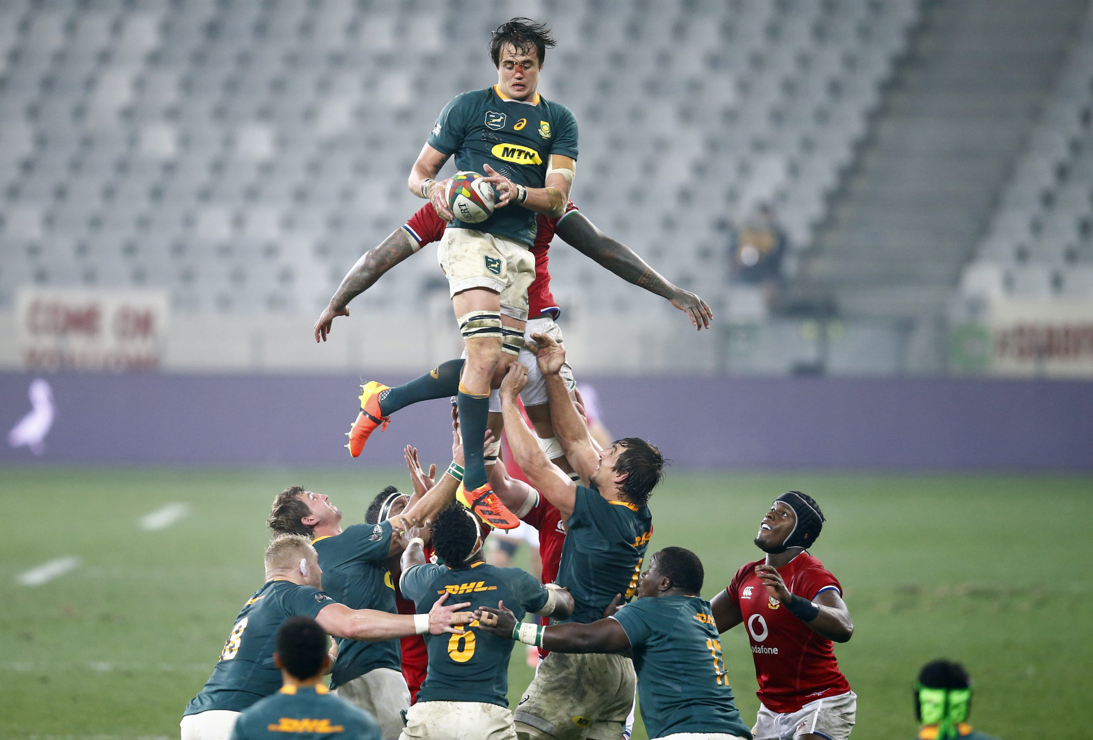 Rugby player mid air after catching ball in line-out.