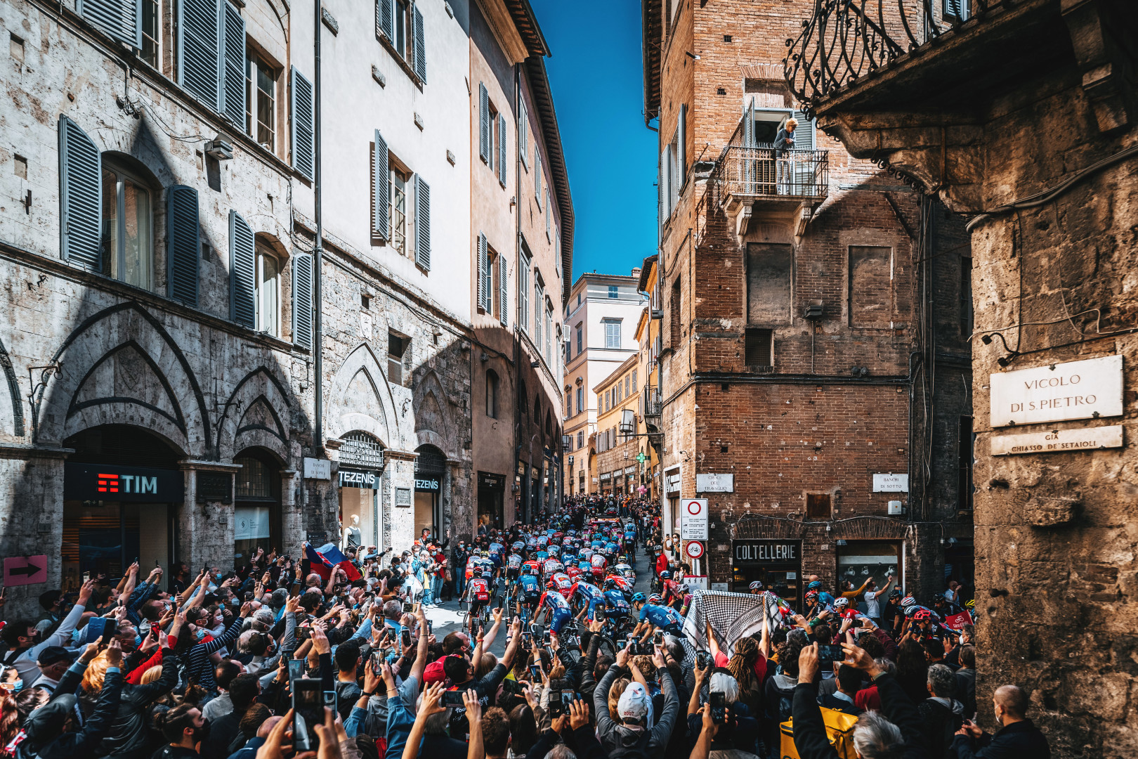 Cyclists cycling through the narrow streets of Siena in the Giro d'Italia.