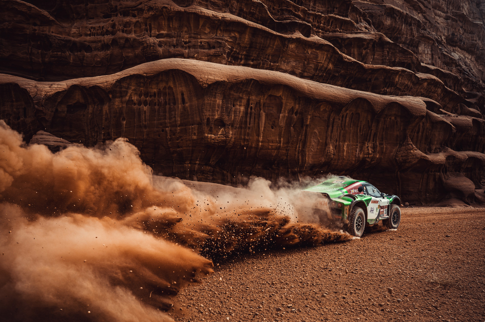 Rally car racing through canyon like dirt track.