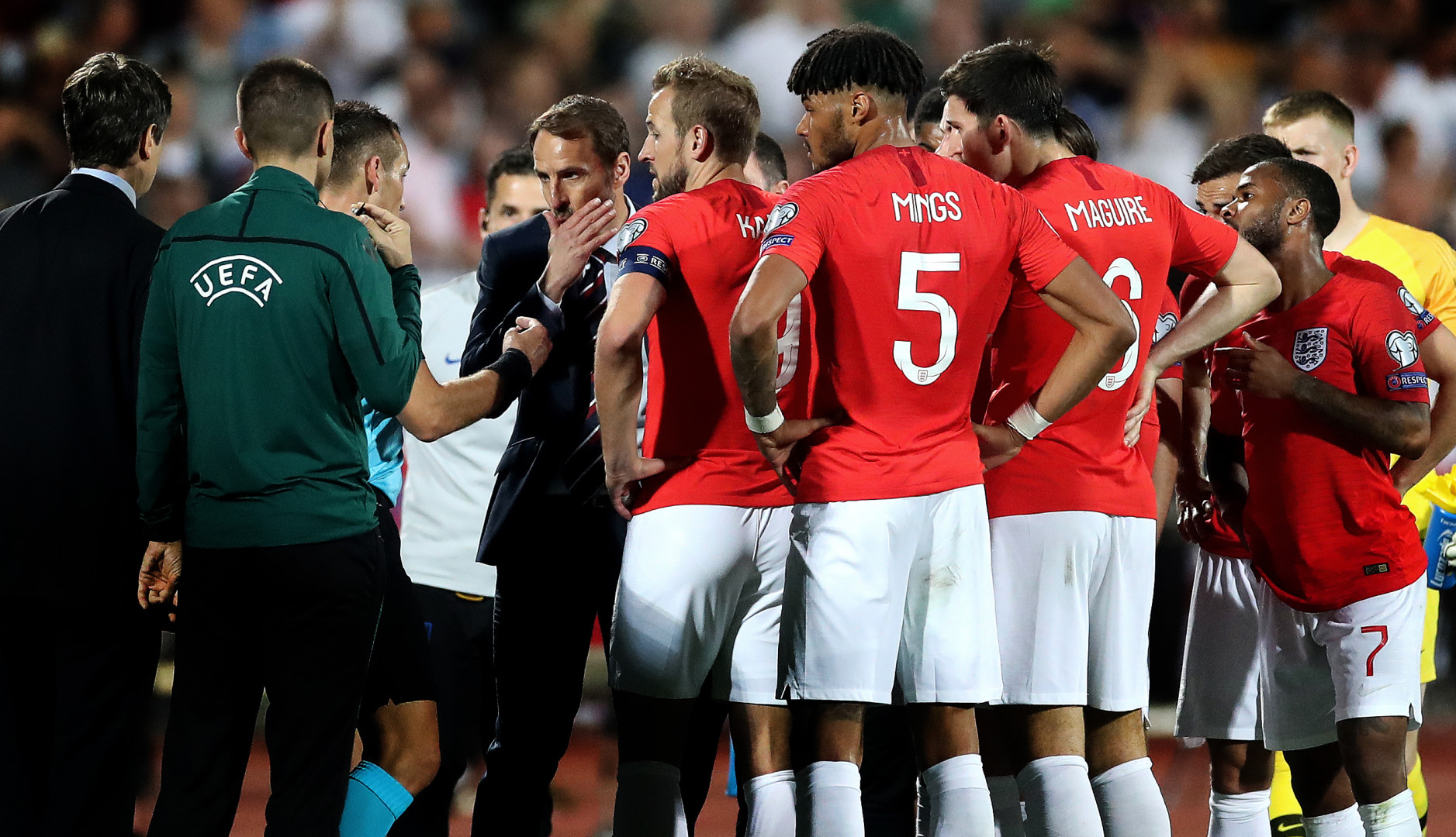 England football team in conversation with UEFA officials at the side of the pitch.