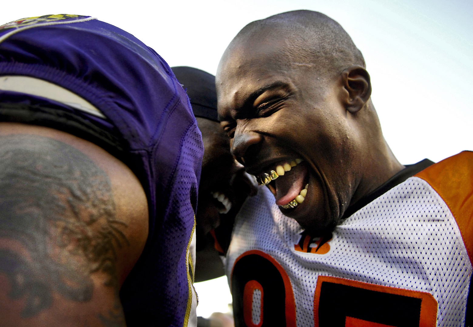 Two American Football teammates screaming joyfully at each other whilst celebrating.