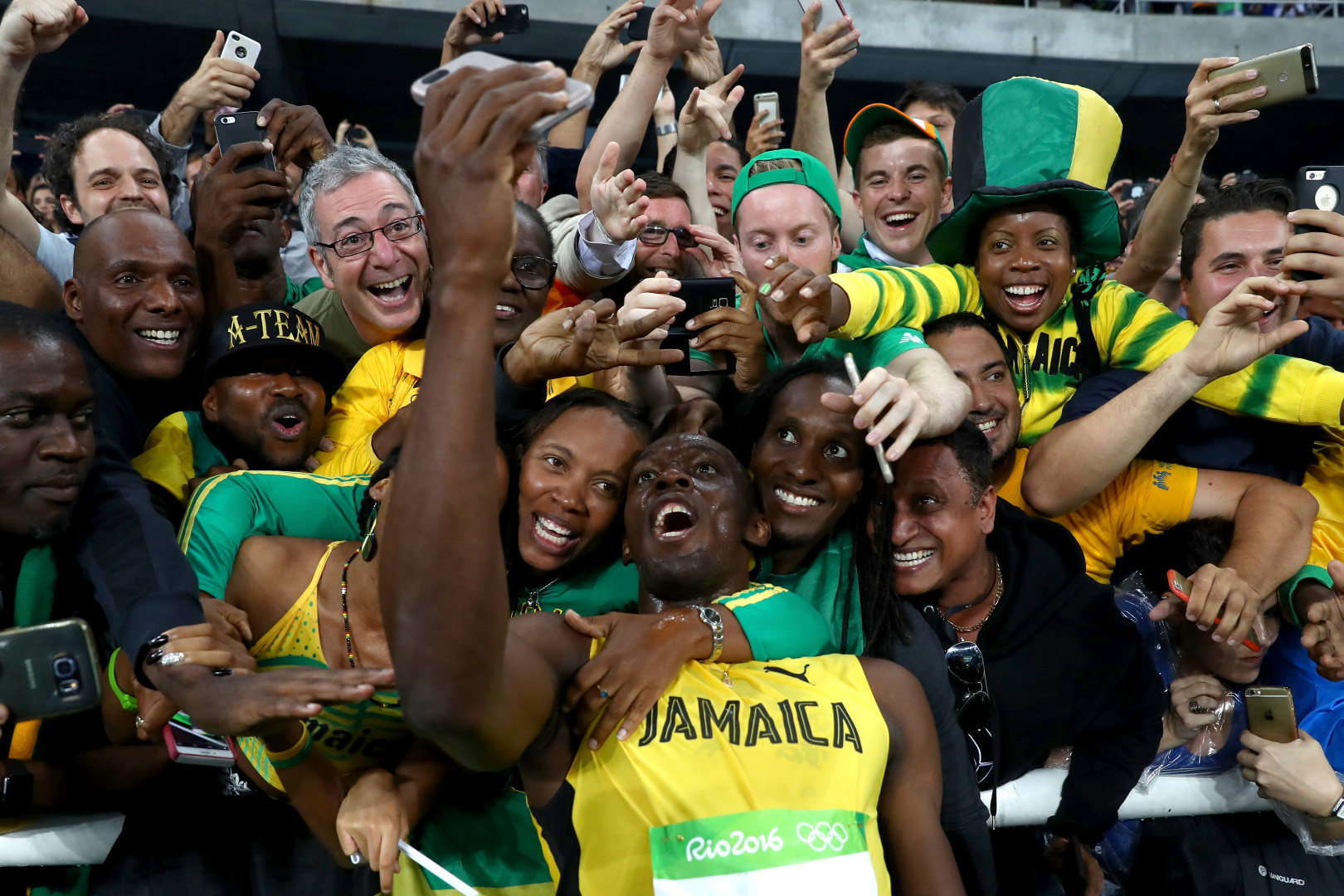 Usain Bolt taking a celebratory selfie with crowd after win.