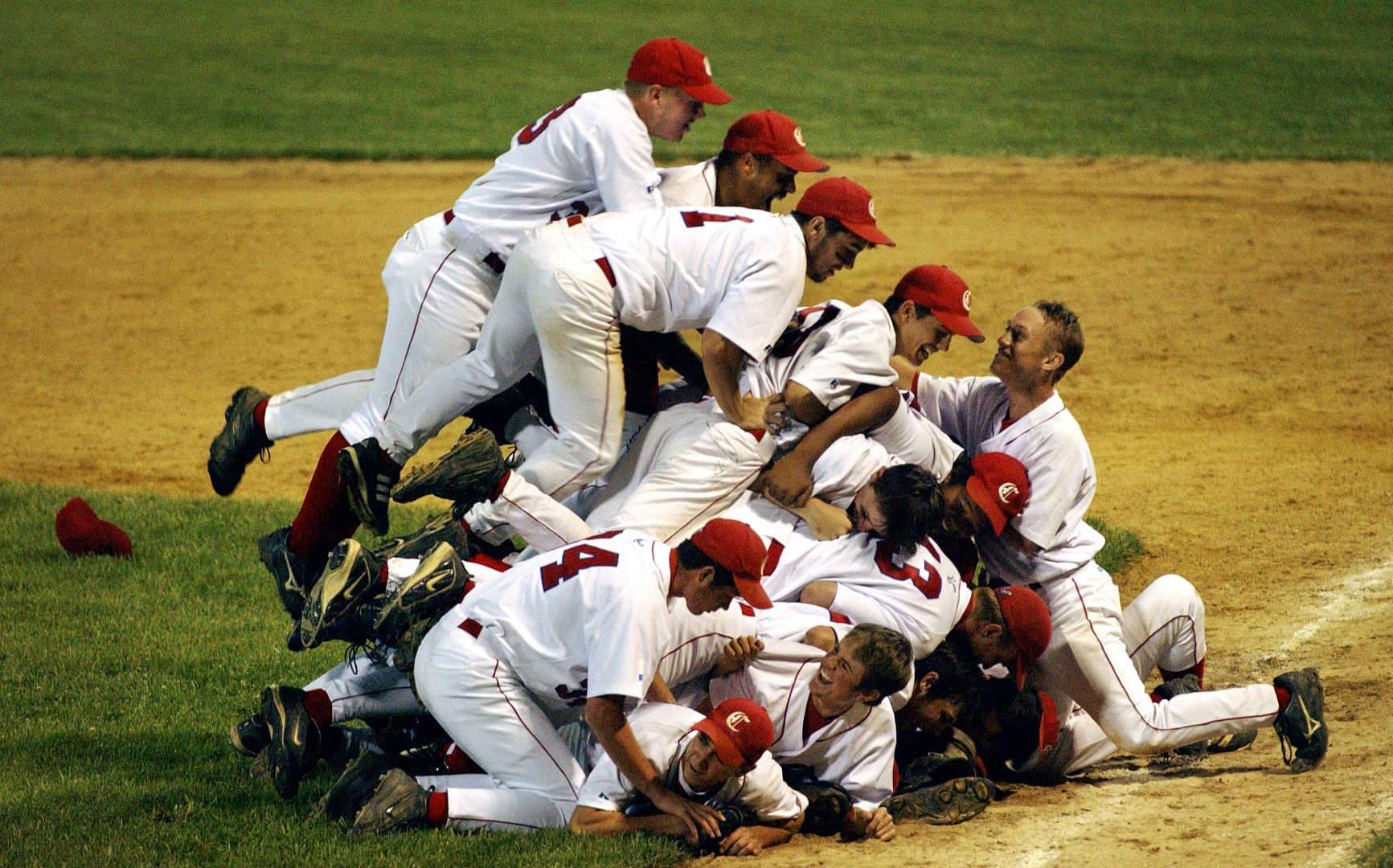 Baseball players pileup as they celebrate victory.