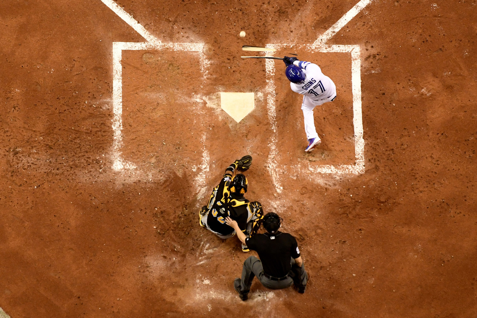 Birdseye view photograph of batsman mid swing after hitting the baseball.