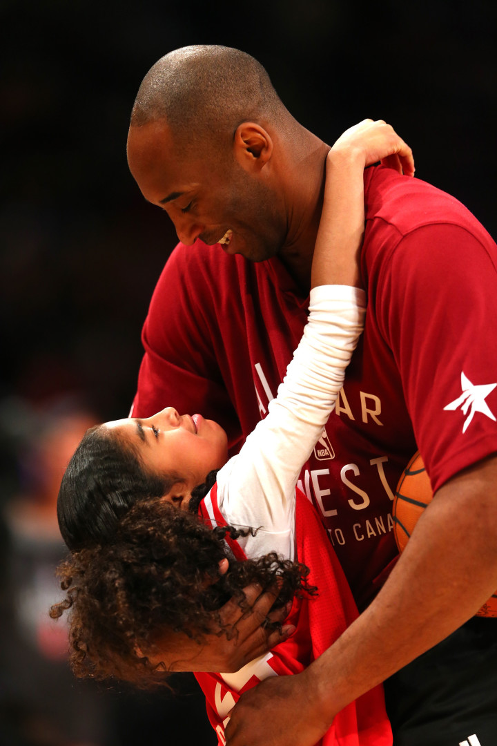 Kobe Bryant and daughter Gianna hugging each other on the basketball court.