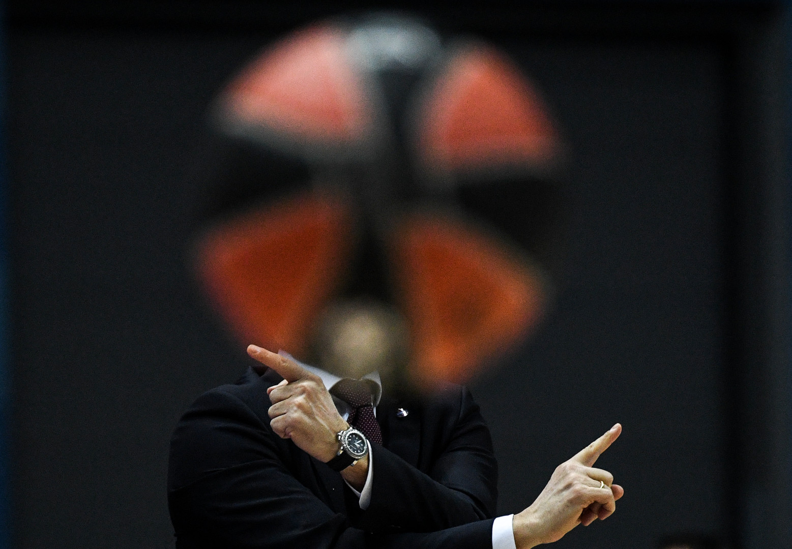 CSKA's head coach's head blocked out by big blurred basketball.