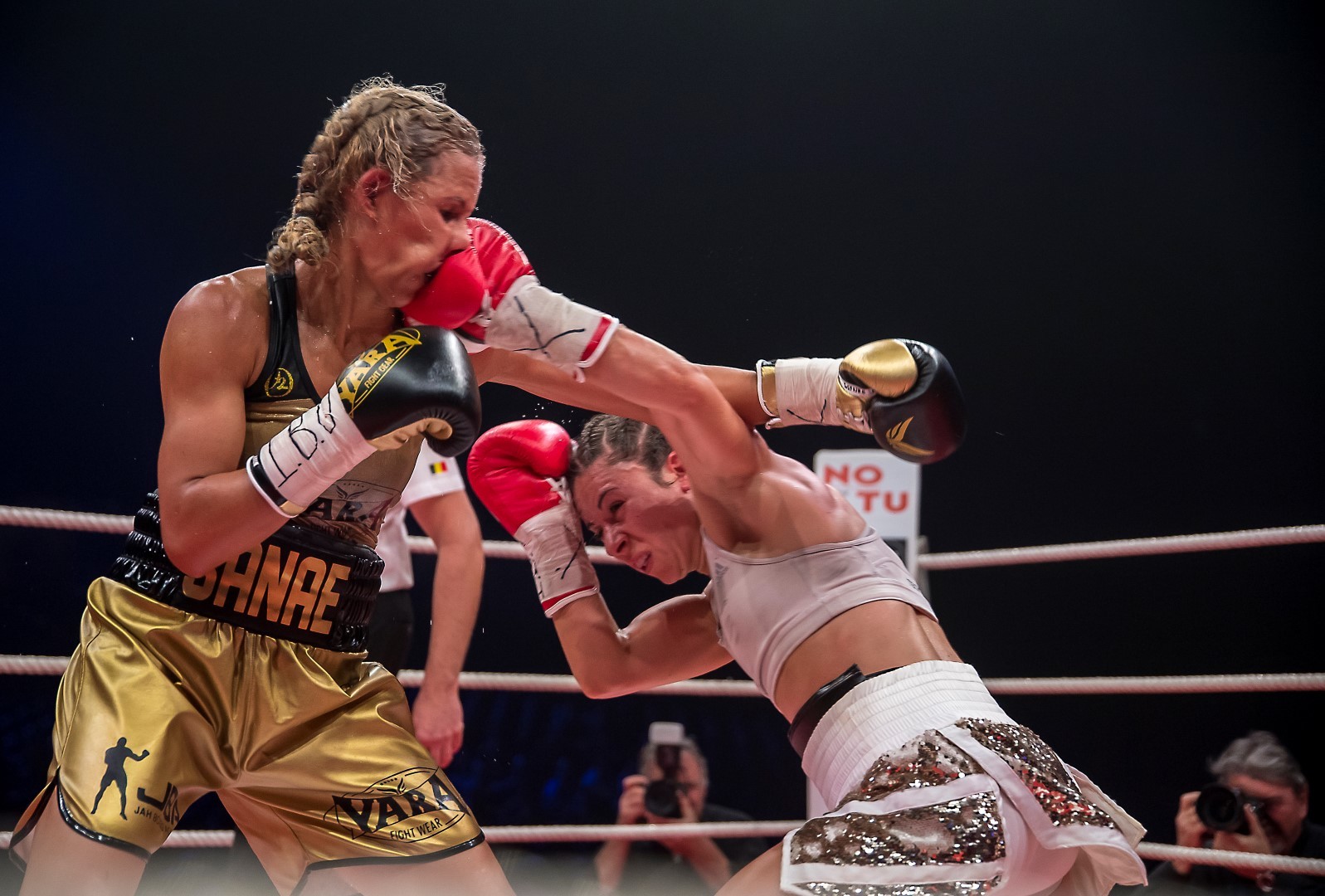 Female boxer landing a punch in the face of opposing boxer.