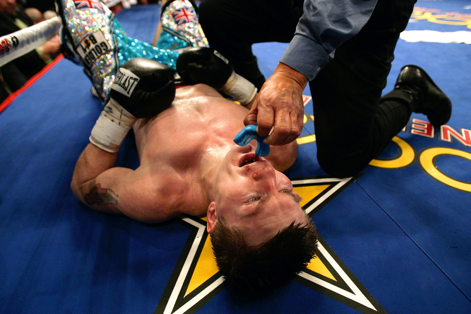 Referee, Joe Cortez, removing mouth guard from flawed boxer.
