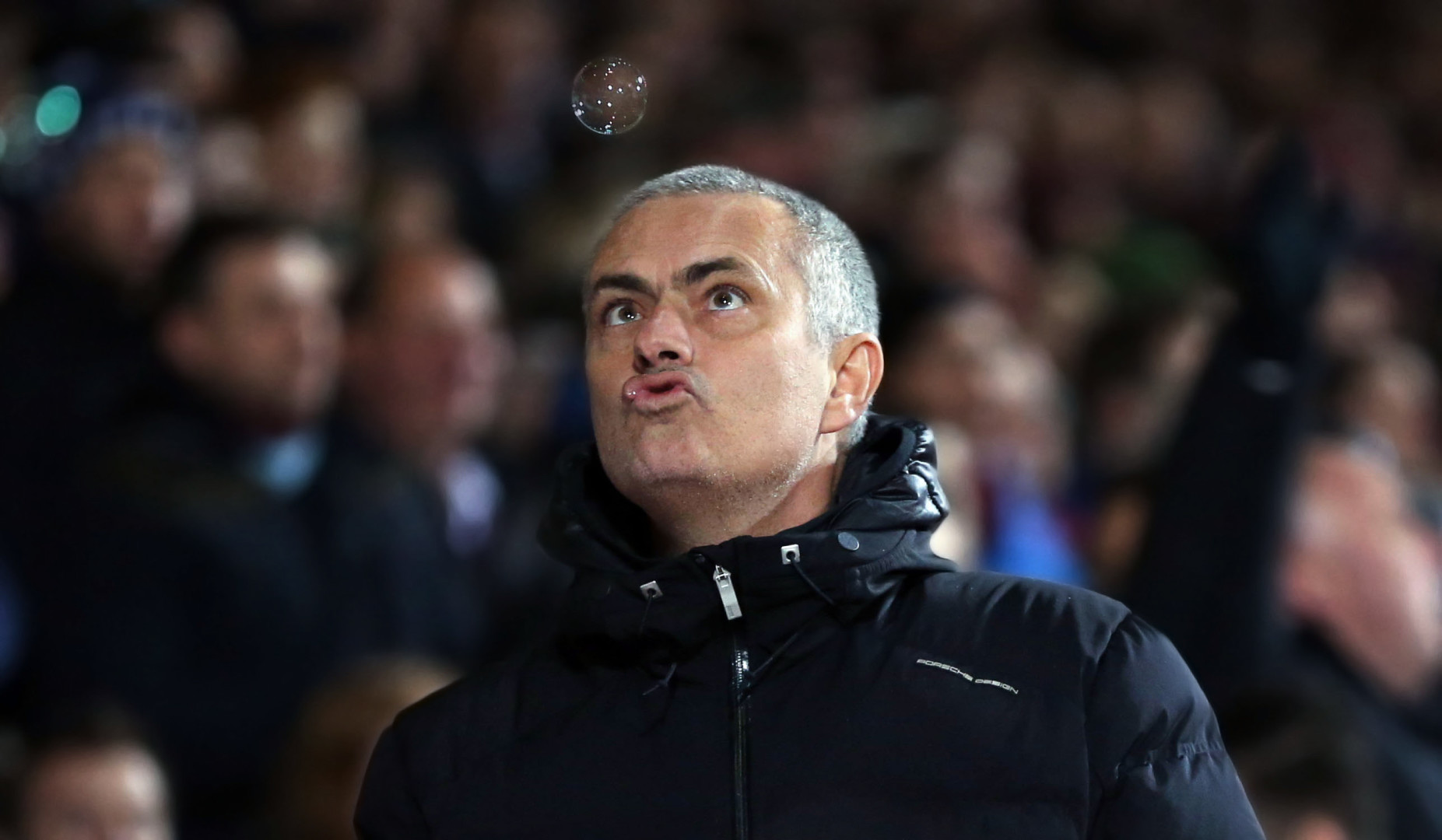 Jose Mourinho pulling a strange face as he blows to pop a bubble.
