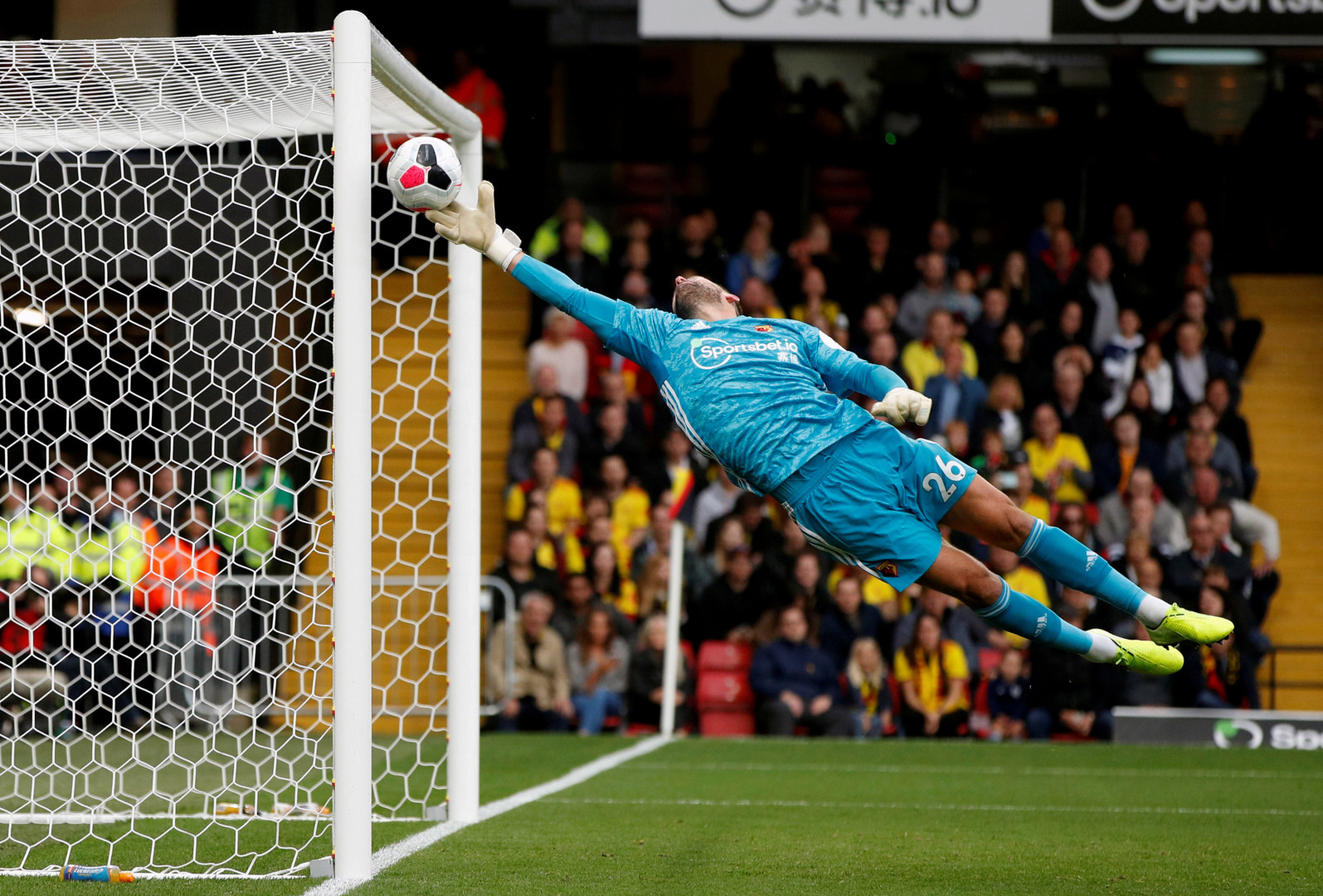 Watford goalkeeper stretching back at full length to save a goal.