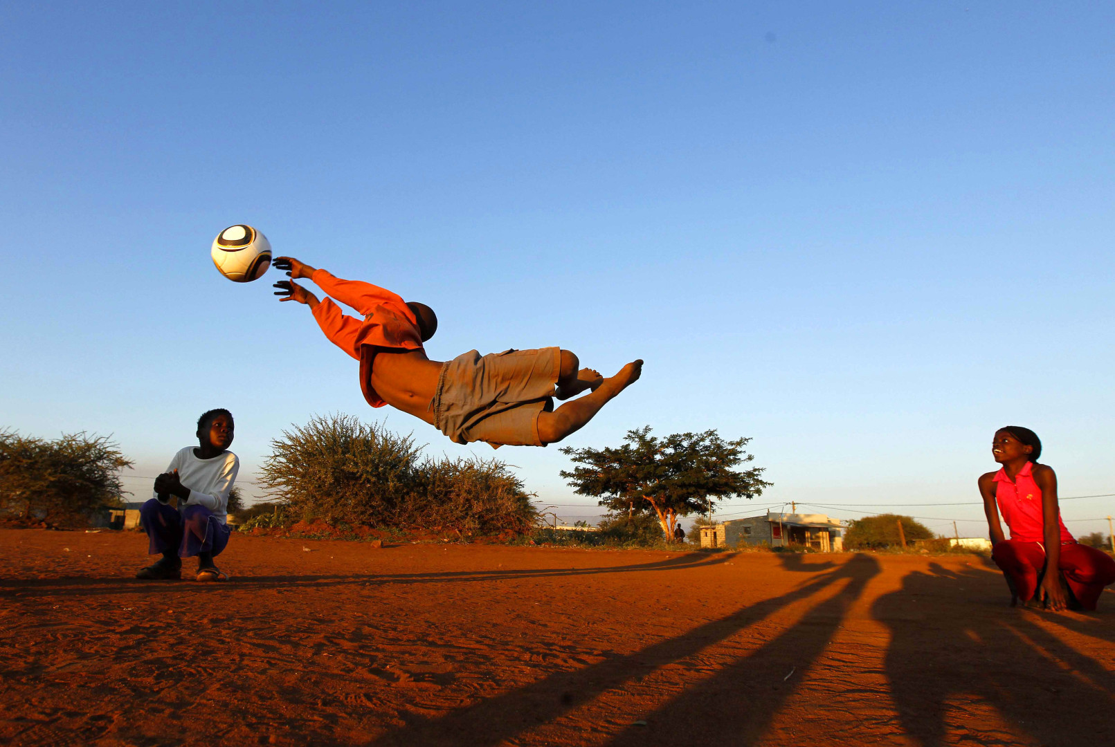 Young boy saves goal as two children act as goal posts in Sun Vally Town.