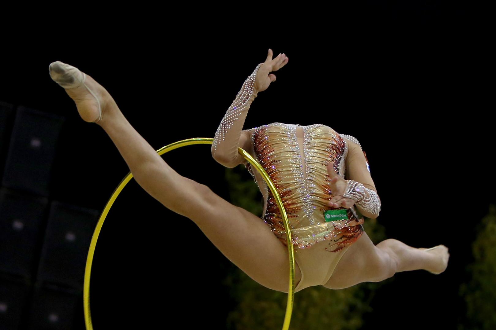Gymnast in a split jump as her head is absent from view.