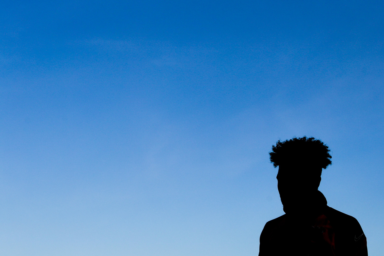 Athlete's silhouette against the gradient blue sky.