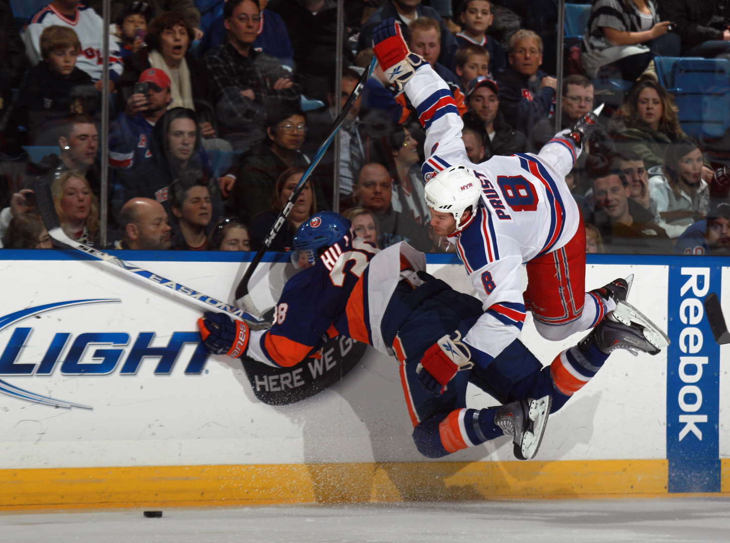 Prust colliding in a starfish position with opposition player as they hit the safety glass.