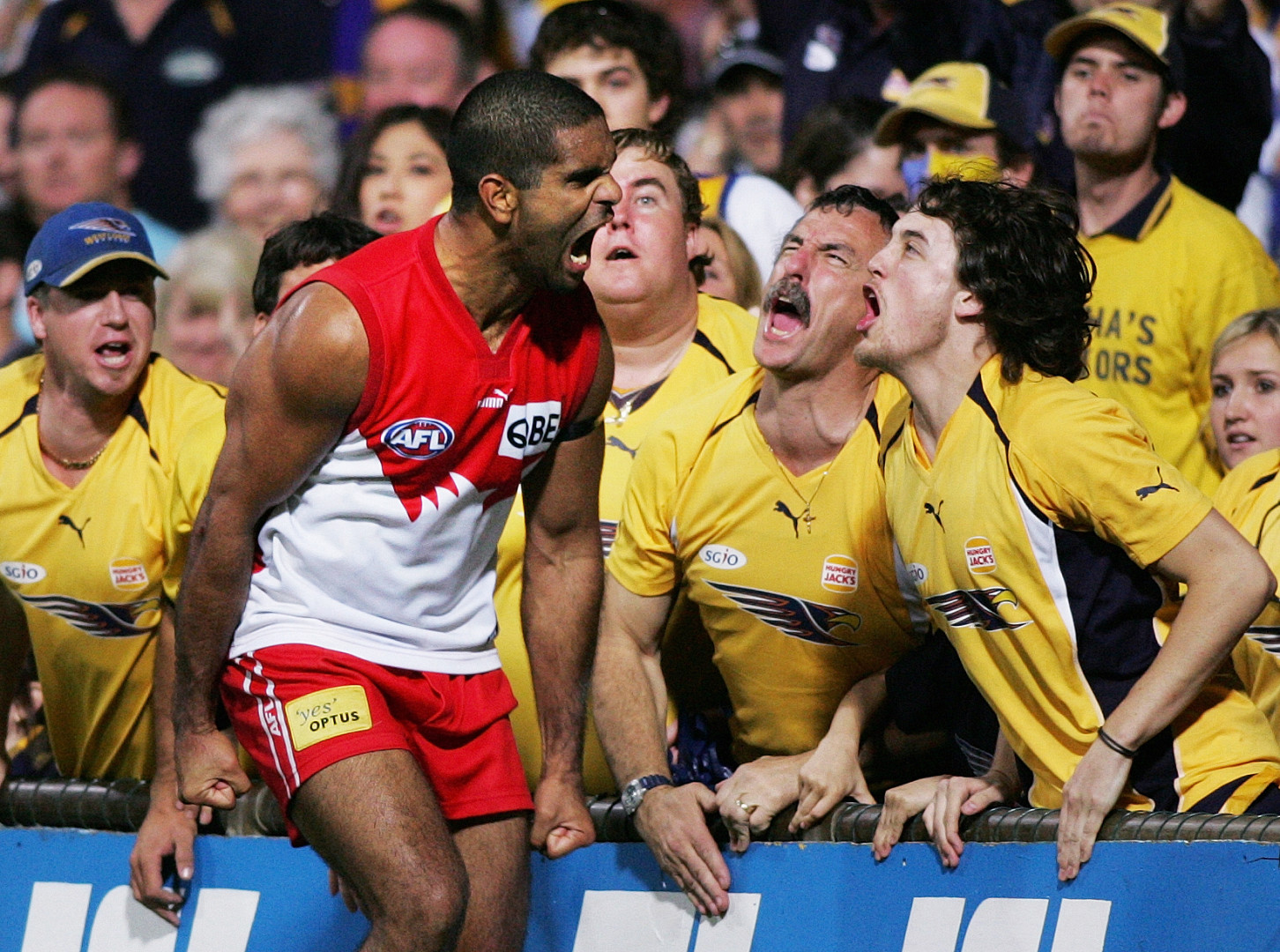 Aussie rules football player screaming at fans in the crowd in celebration.