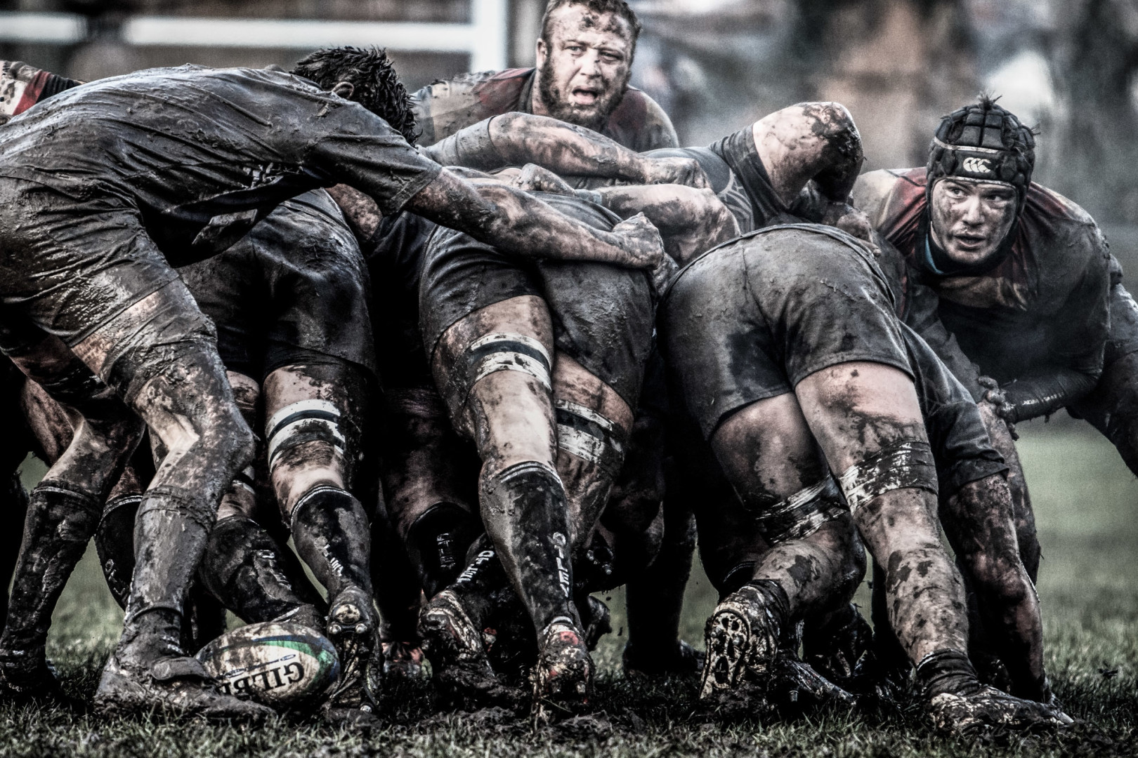 Muddy scrum of rugby players.