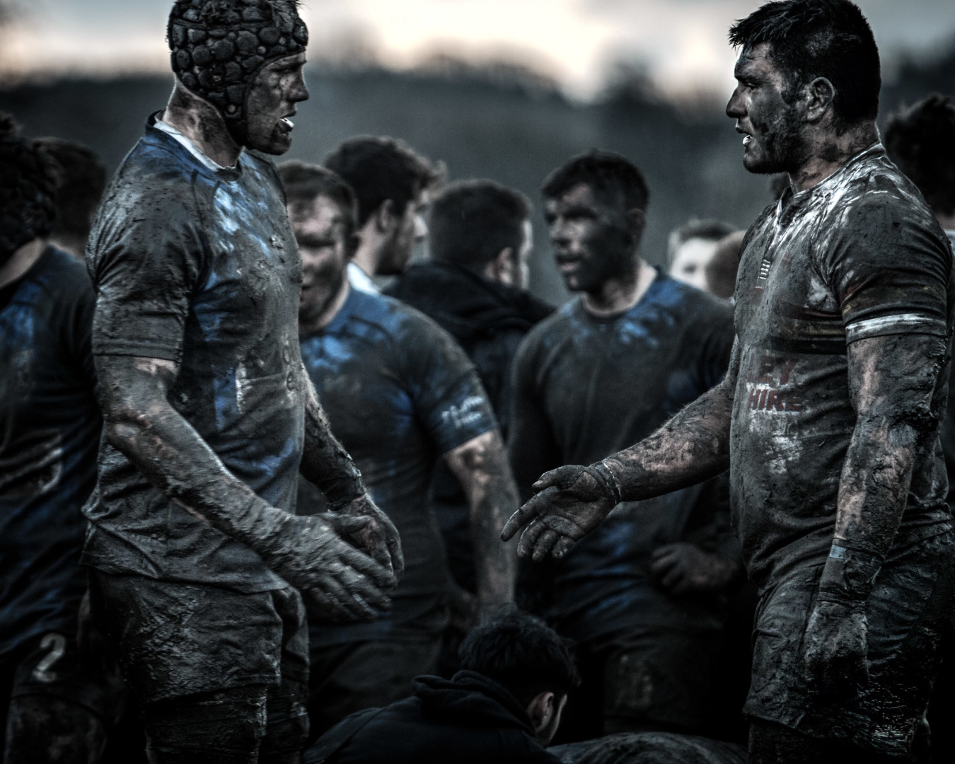 Opposing rugby players showing respect to each other by going to shake each other's hand.