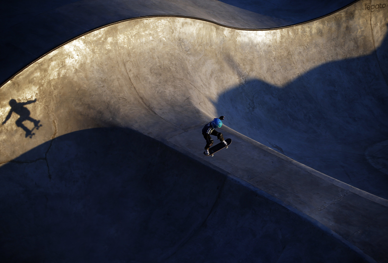 Young skater training in evening light at the skate park.