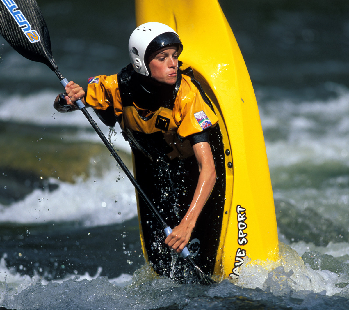 Kayaker on point of kayak in strong waters.