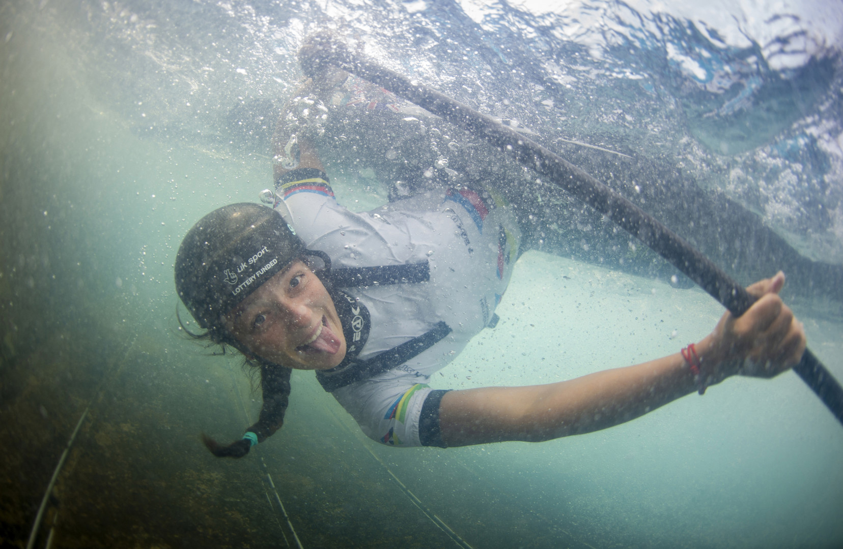 Mallory Franklin smiling at the camera lens under water as she capsizes her canoe.
