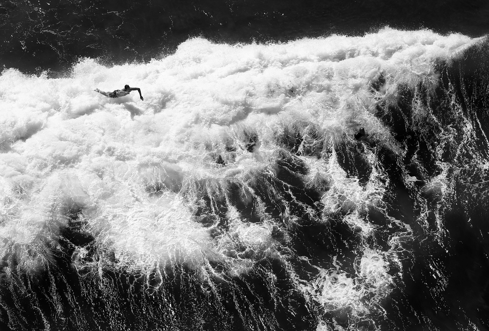 Black & White image of swimmer launching himself into the breaking waves of the sea.