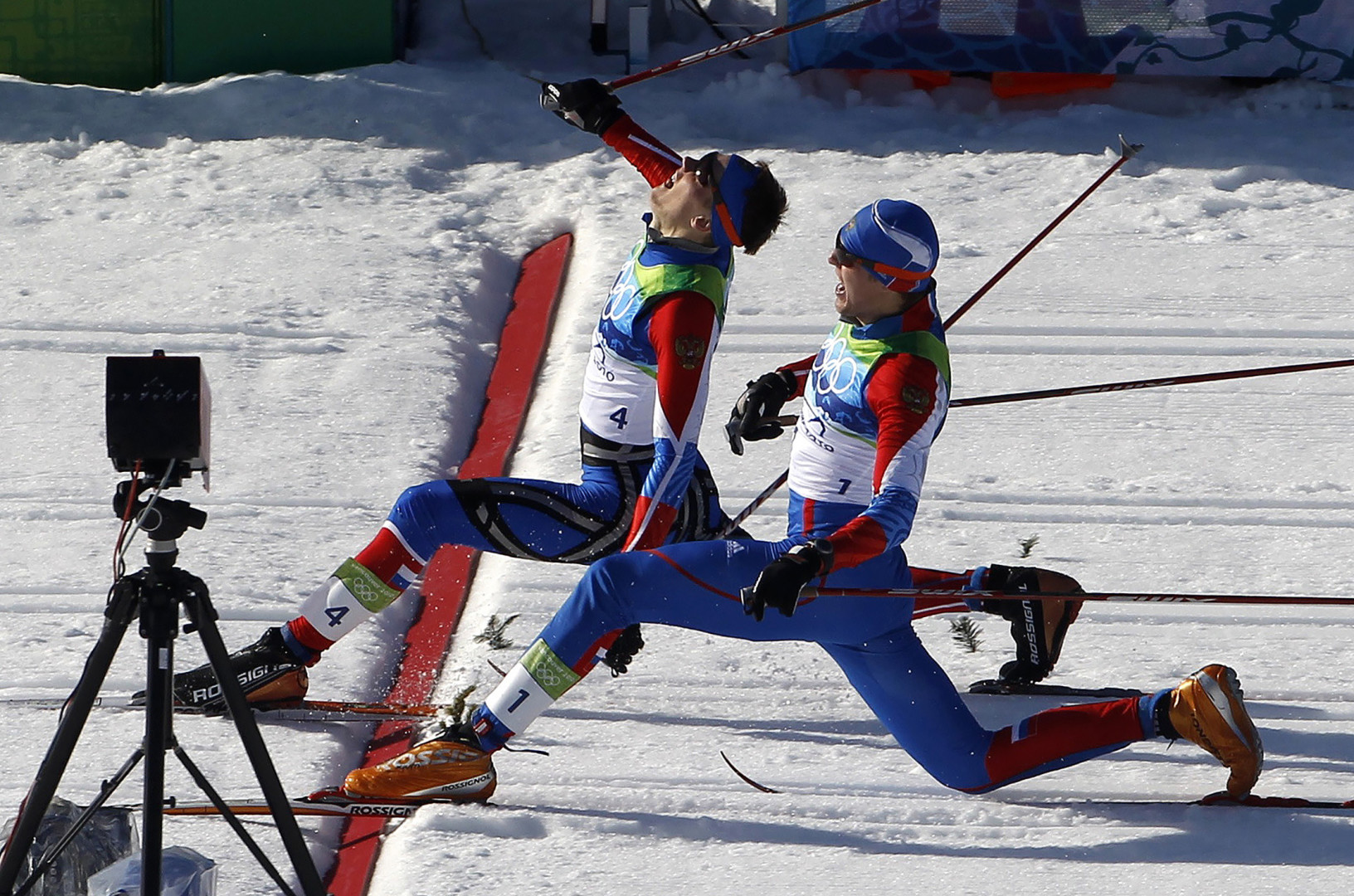 Snow skiers stretching to cross the finish line at the Winter Olympics.