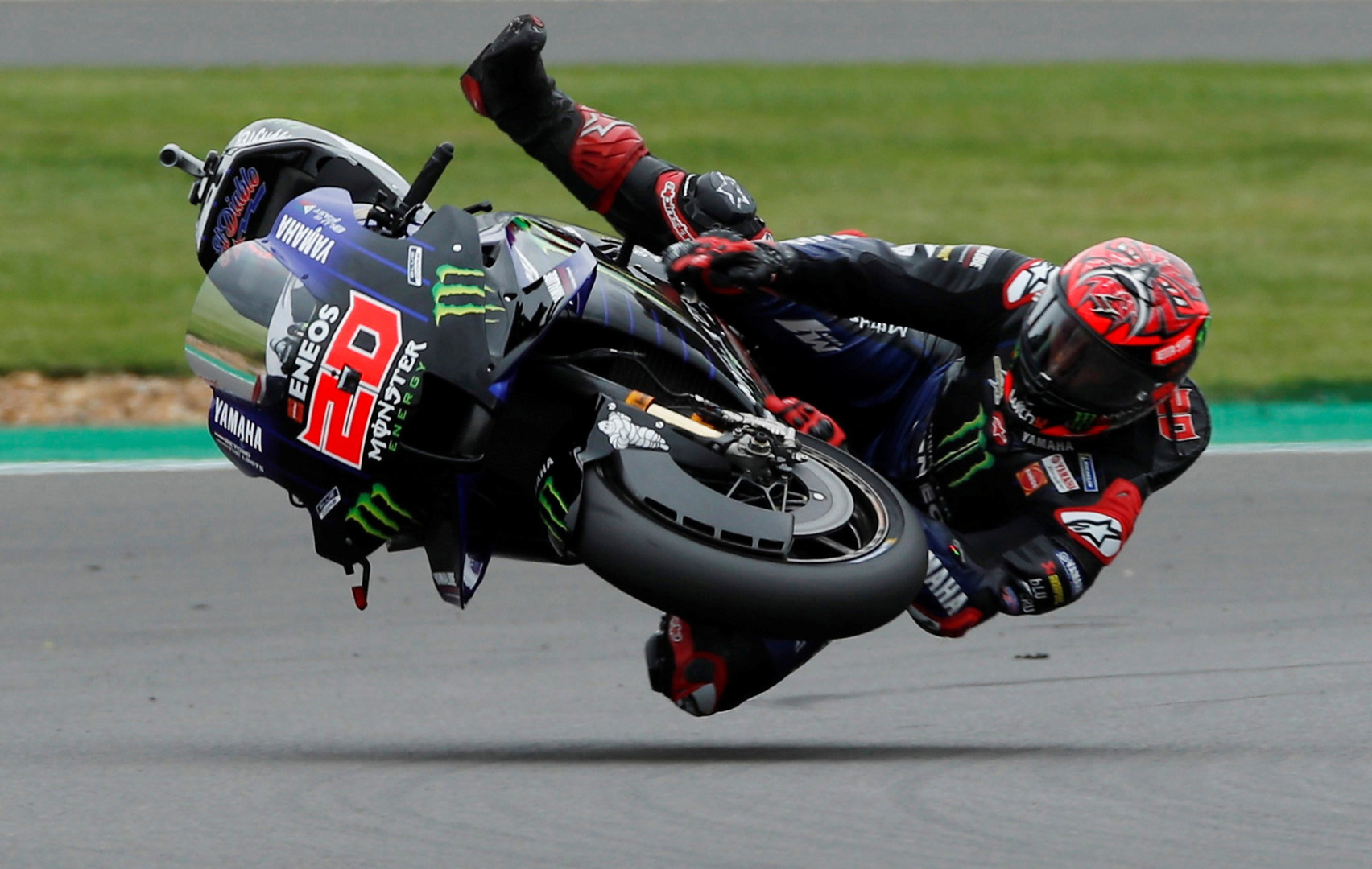 Fabio Quartararo flying off his motorcycle on the track during a race.