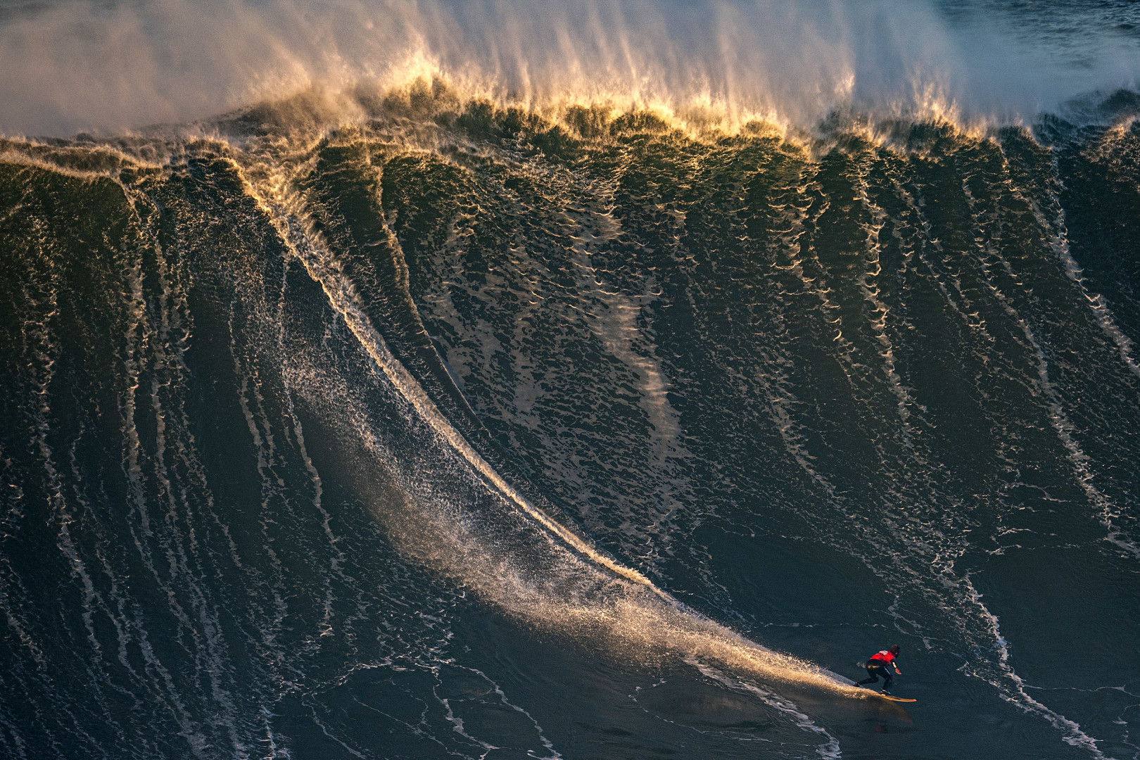 Lucas Chumbo dropping in on a massive wave during surf competition.