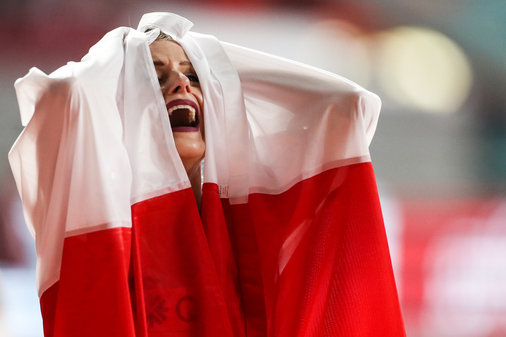 Euphoria as female athlete celebrates win wrapped in national flag.