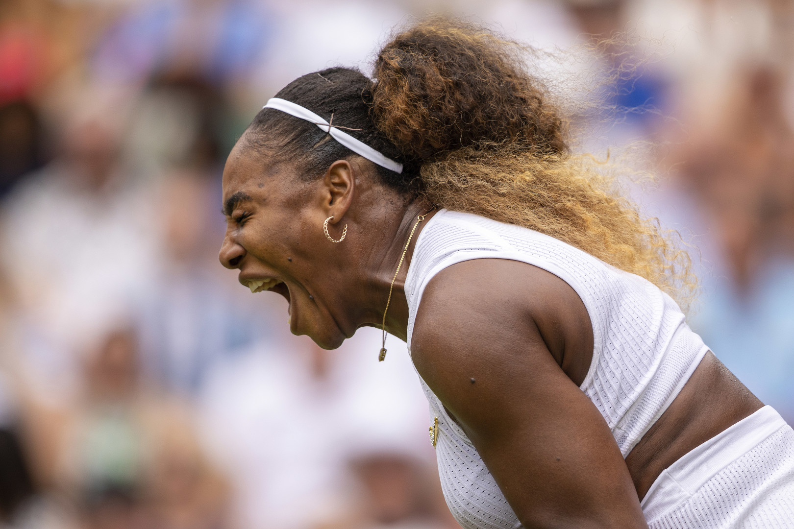 Close up photograph of Serena Williams screaming after winning a point during the Wimbledon Tennis Championships.
