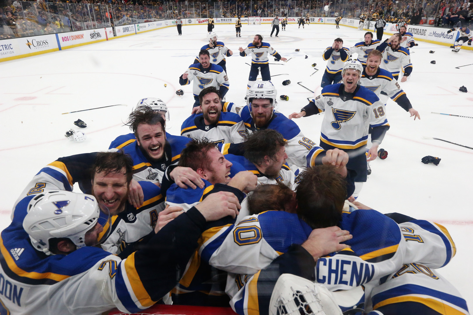 Ice Hockey team celebrating in huddle up against the glass as they win hockey match.