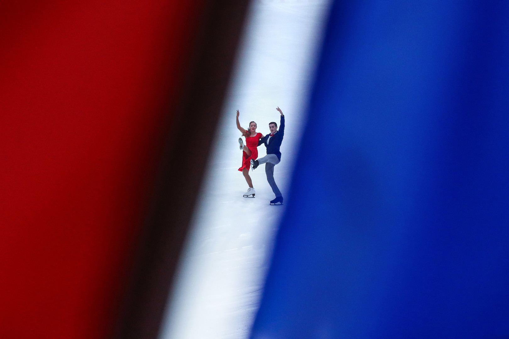 Ice skaters caught through the gap wall, with the colours reflecting the French flag.