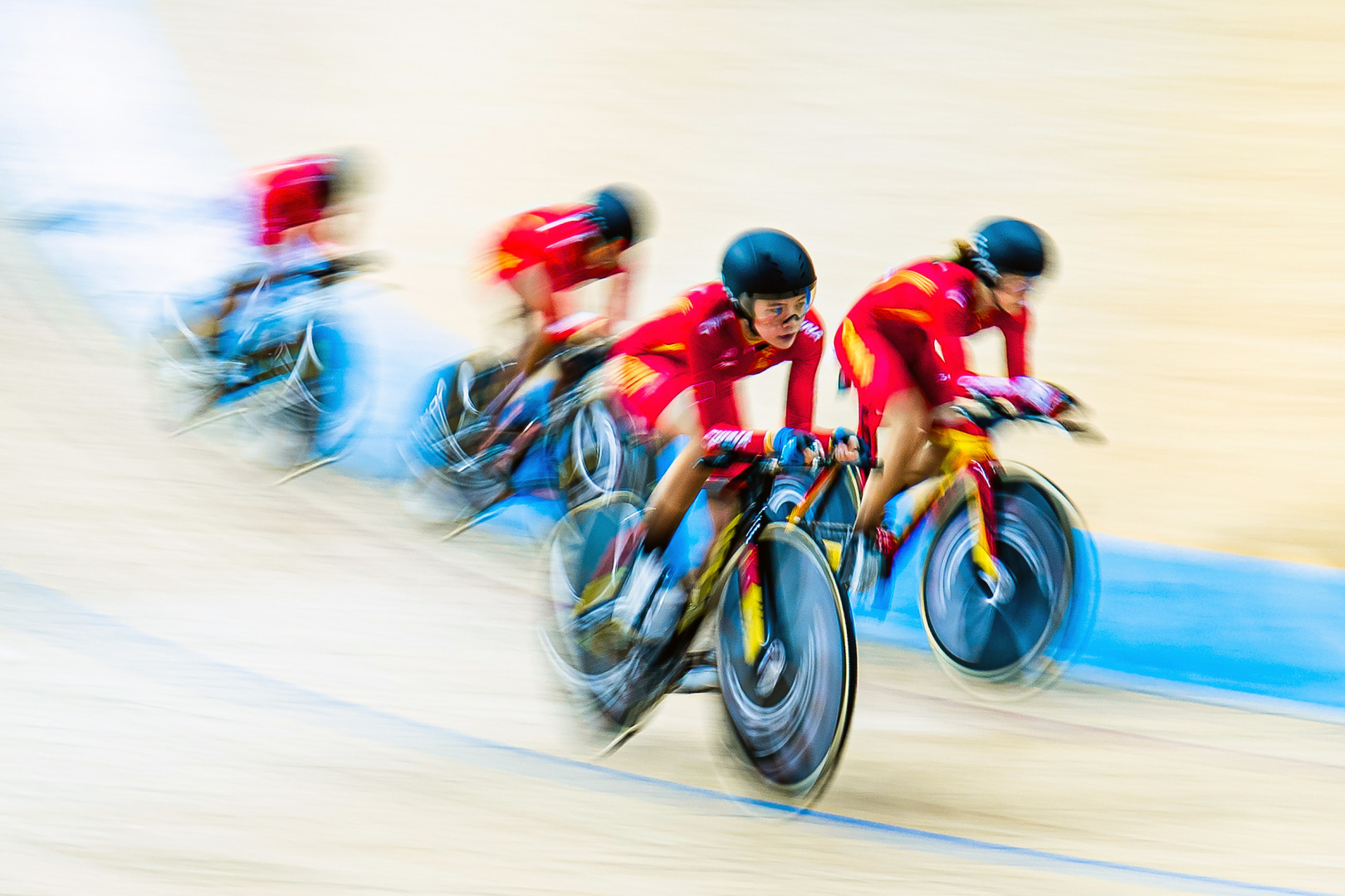 Velodrome cyclist movement in motion caught as she moves over to let other team mate take the lead in group race.