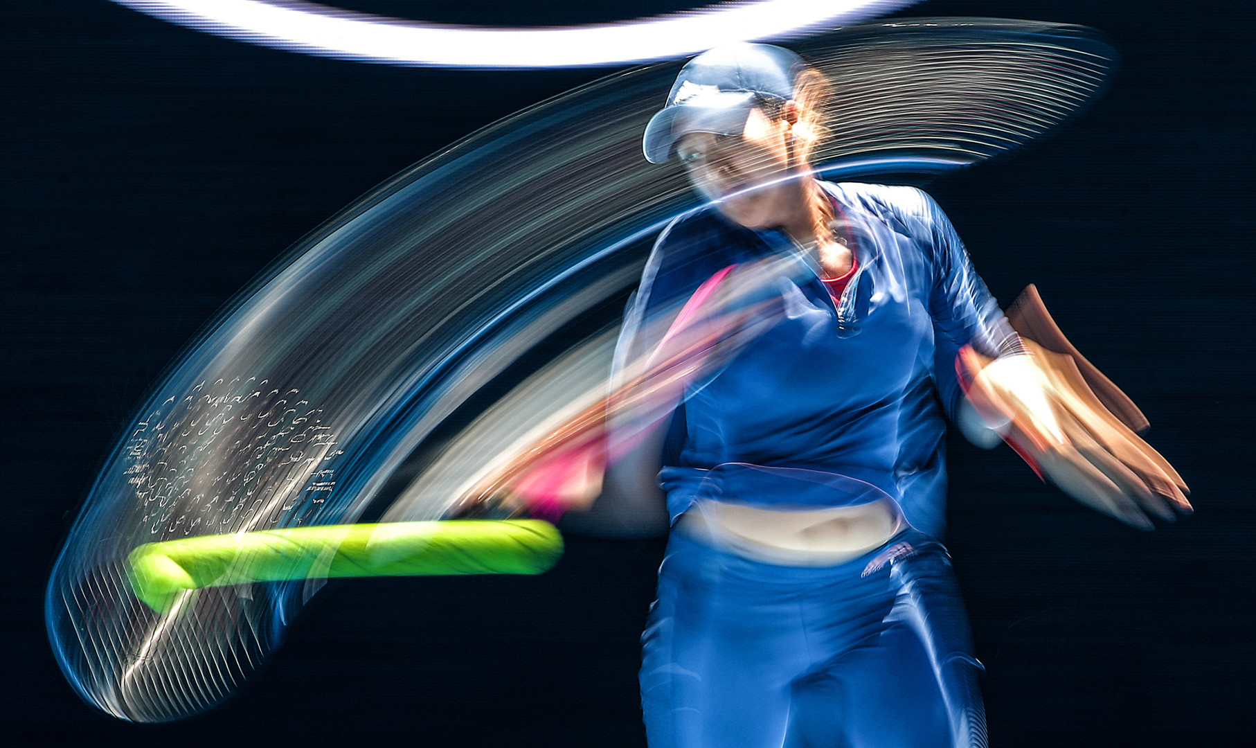 Tennis racquet movement caught in motion as Naomi Osaka swings her racquet to return the serve during a Tennis match.