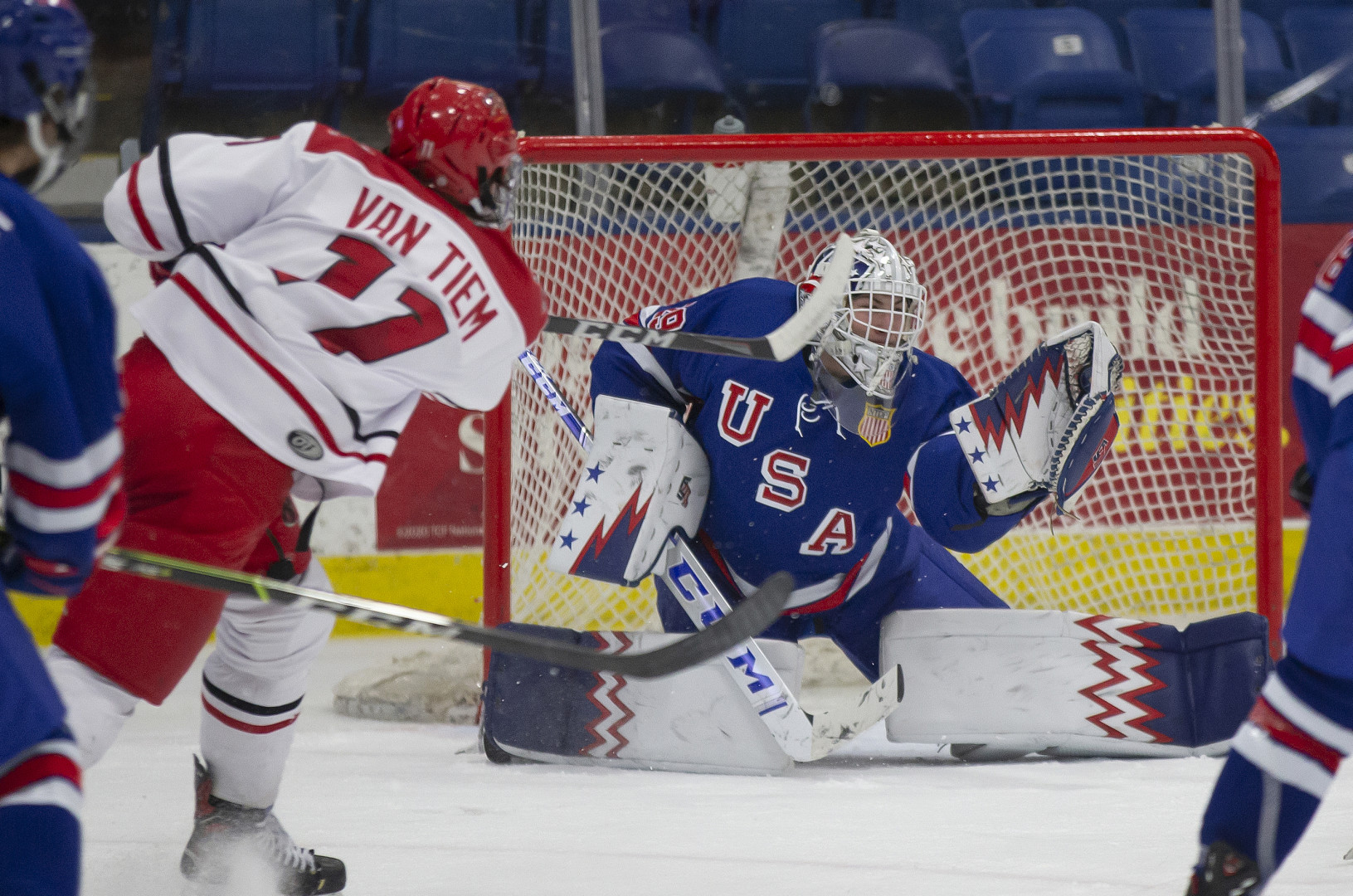 USA ice hockey goal keeper saving a shot from the opposition team.