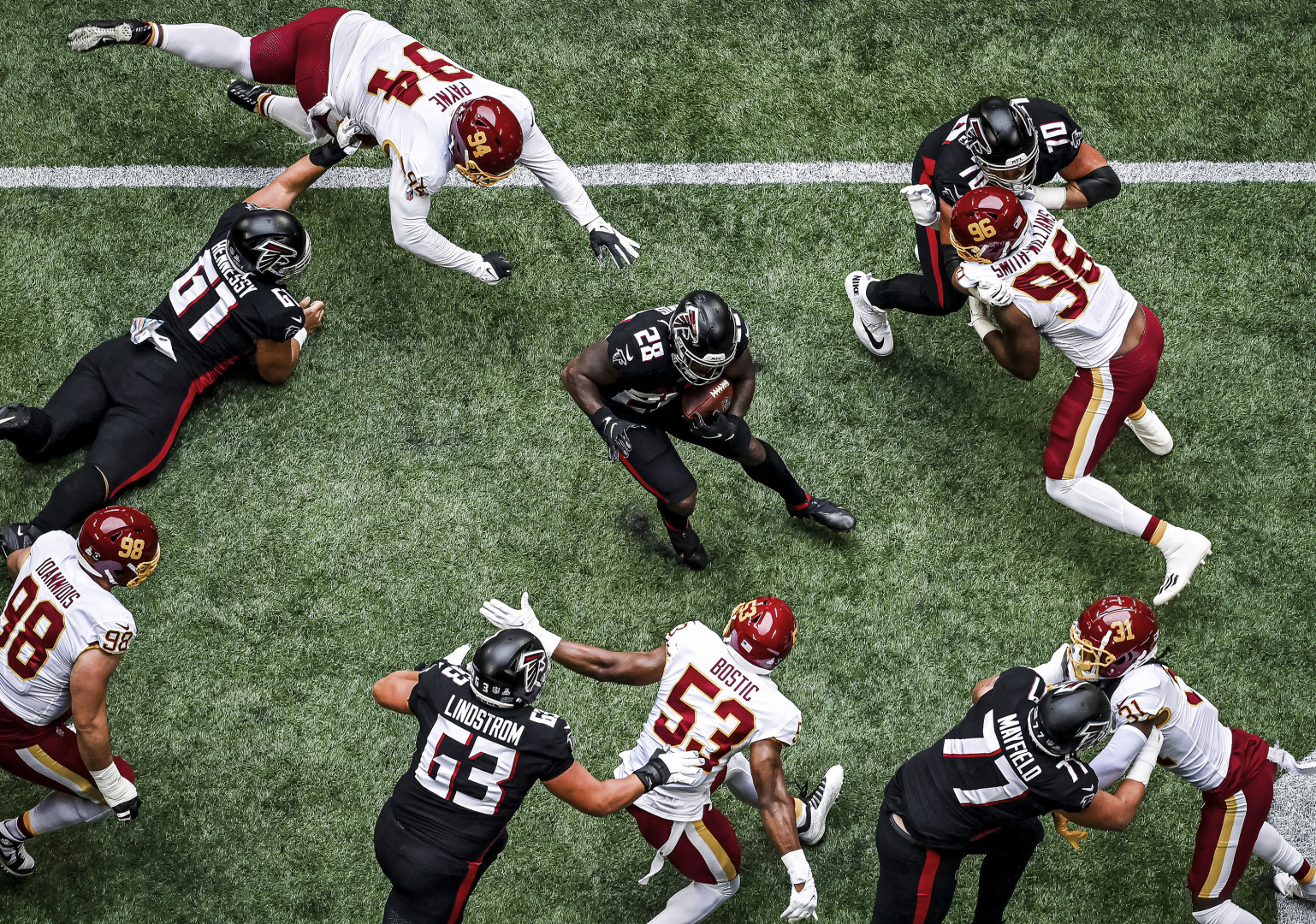 NFL player dodging his opponents with his quick feet.