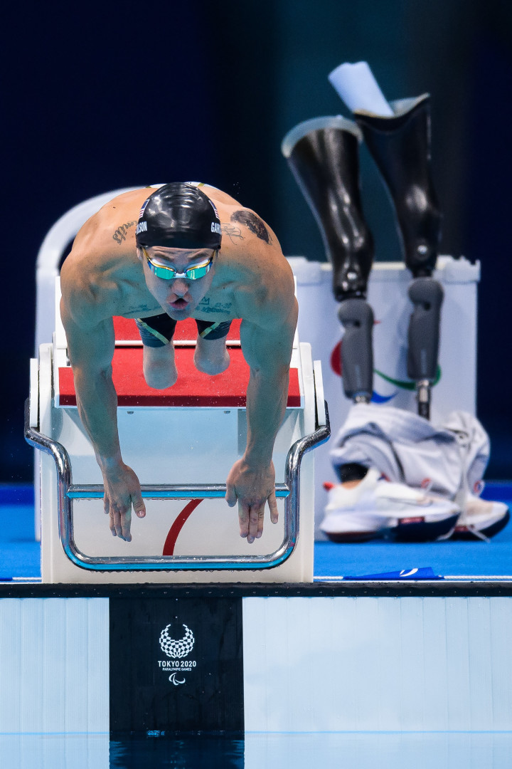 Paralympic swimmer, Rudy Garcia-Tolson, jumping off the diving board into the swimming pool.