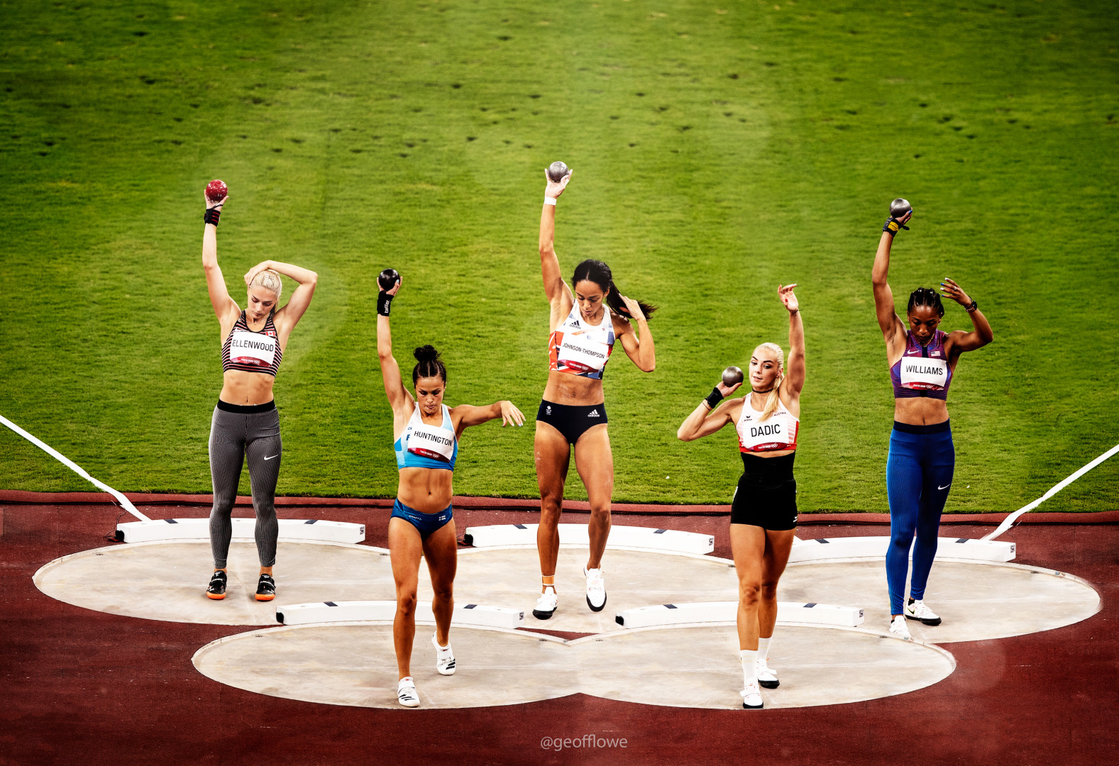 Five female Heptathletes practising their shot put positioning on the side of the field.