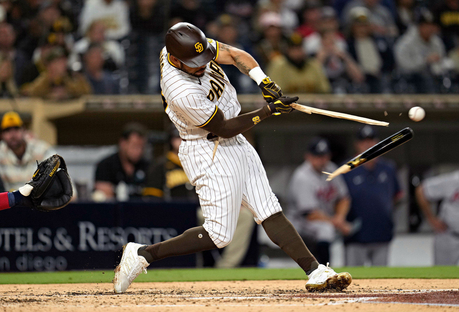 Baseball batter's bat snaps in half as he hits the baseball.