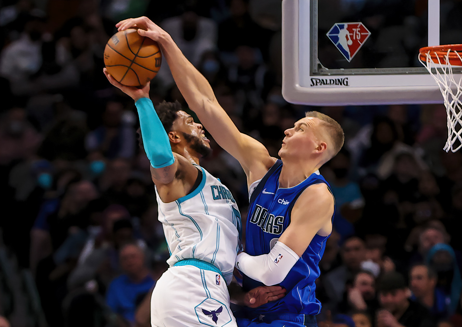 Dallas Maverick's basketball player blocking the shot of a Charlotte Hornets player.