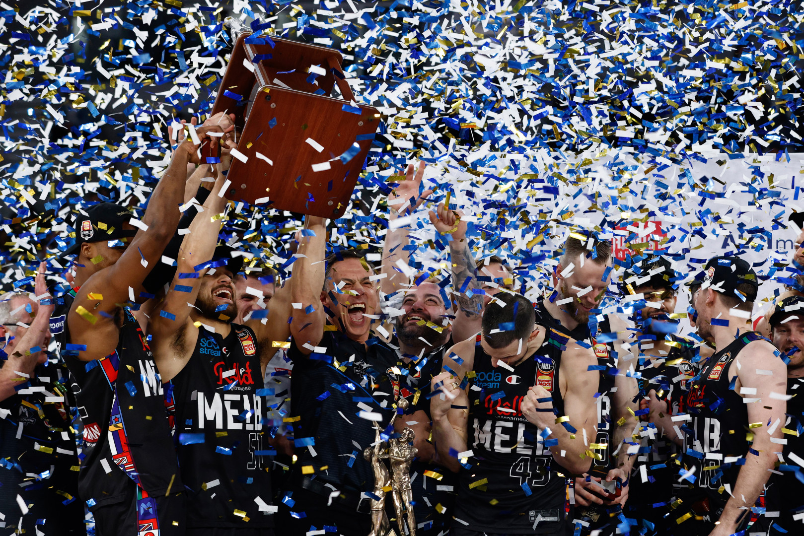 Melbourne United lifting the winning trophy as they are showered with confetti.