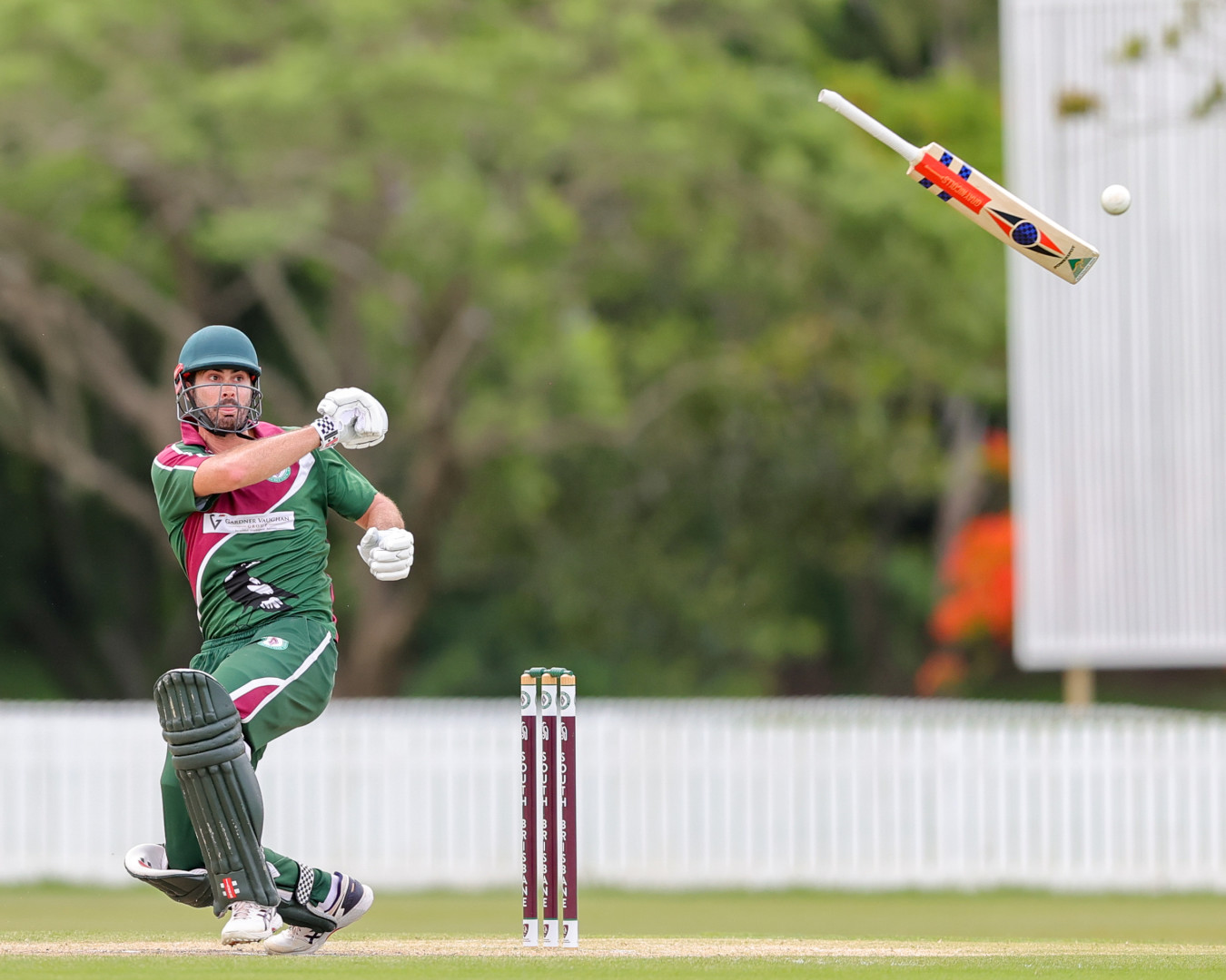 Batsman throwing his bat to hit a cricket ball.
