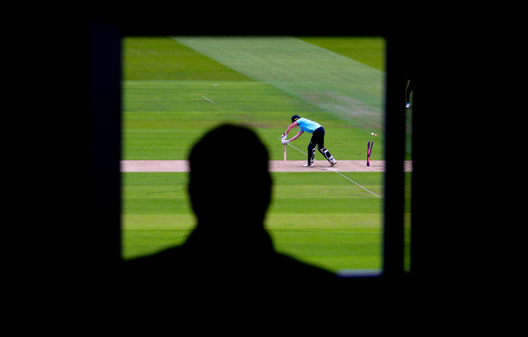 Scorers view of a batter being bowled out during a cricket match.