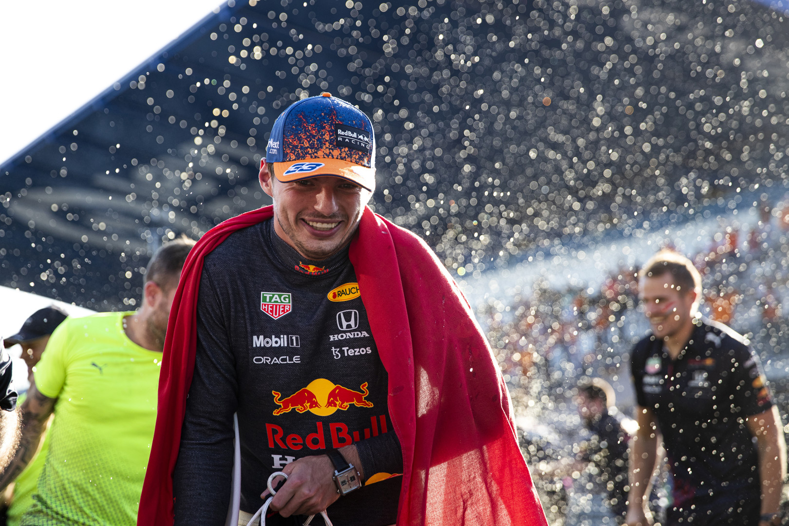 Close up of a smiling Max Verstappen after winning race.