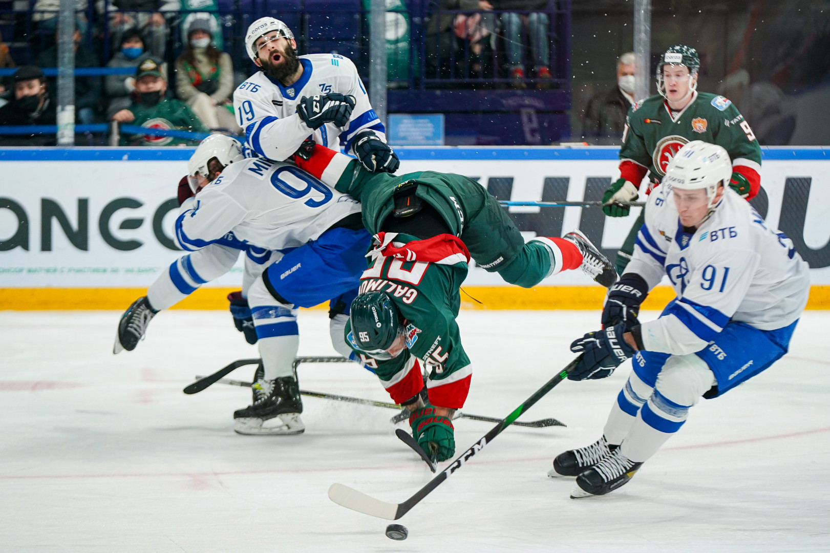 Colliding ice hockey players as another steal the puck.