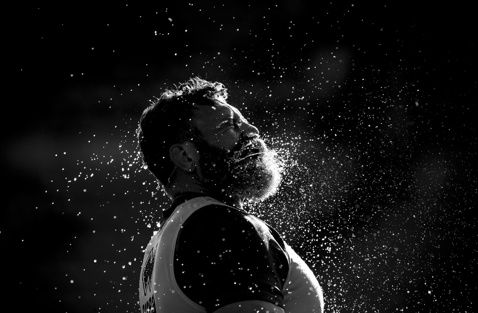 Black & White photograph of Irné Herbst spraying water from his mouth.
