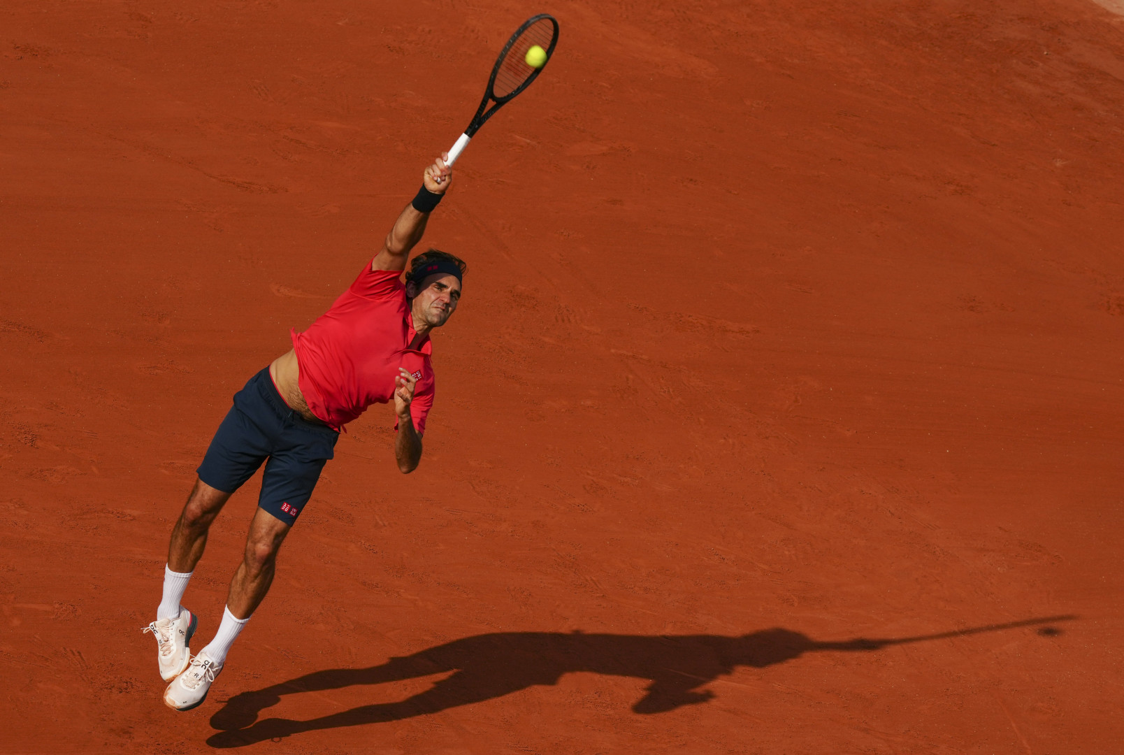 Roger Federer stretching high to hit a shot at the Paris Masters Tennis Tournament.