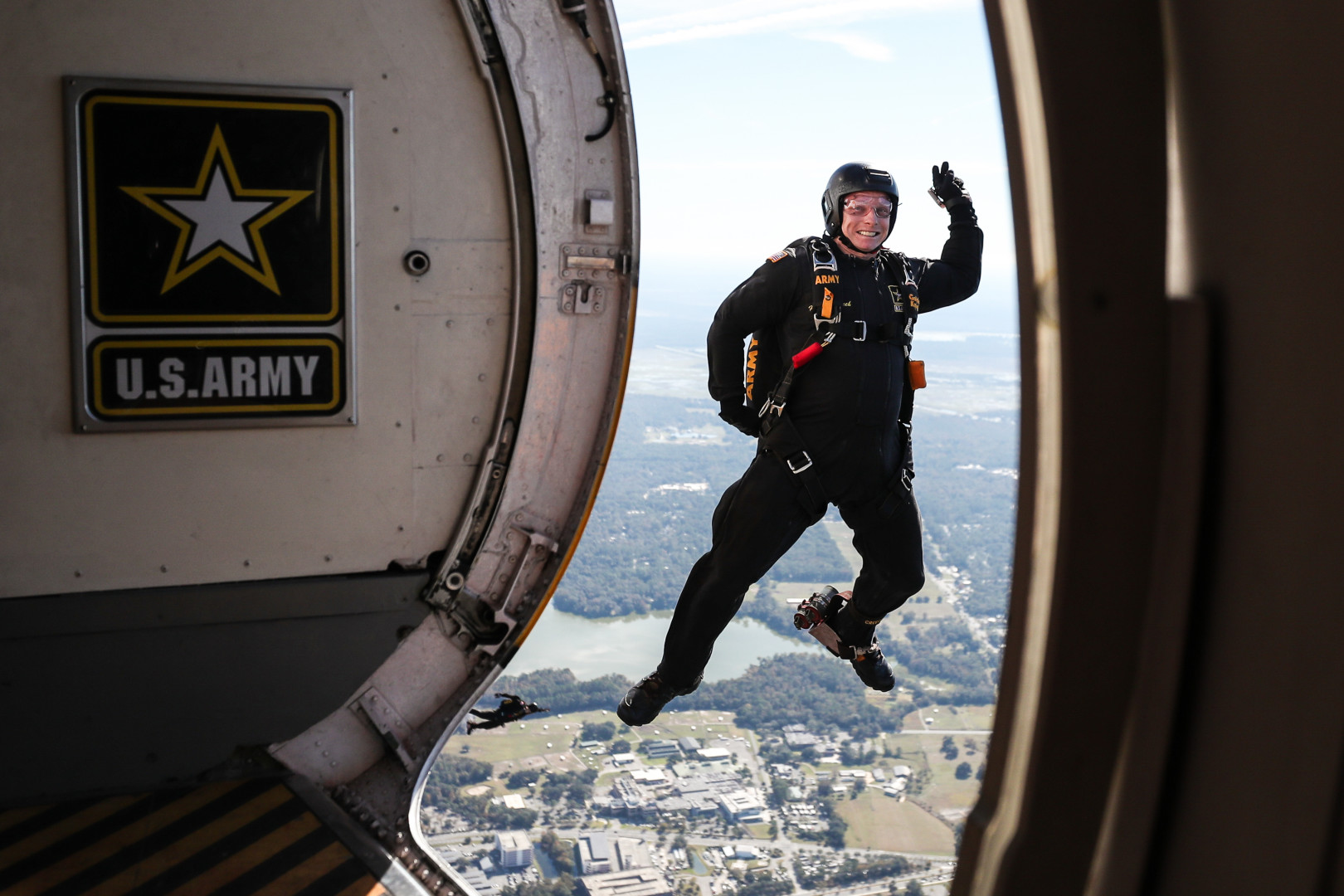 One of the United States Army Parachute Team Jumping out the plane whilst waving to the cameraman in a Skydiving jump.