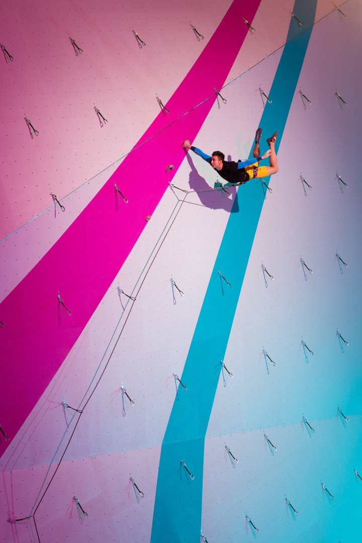 Indoor climber swinging from alpine draws.