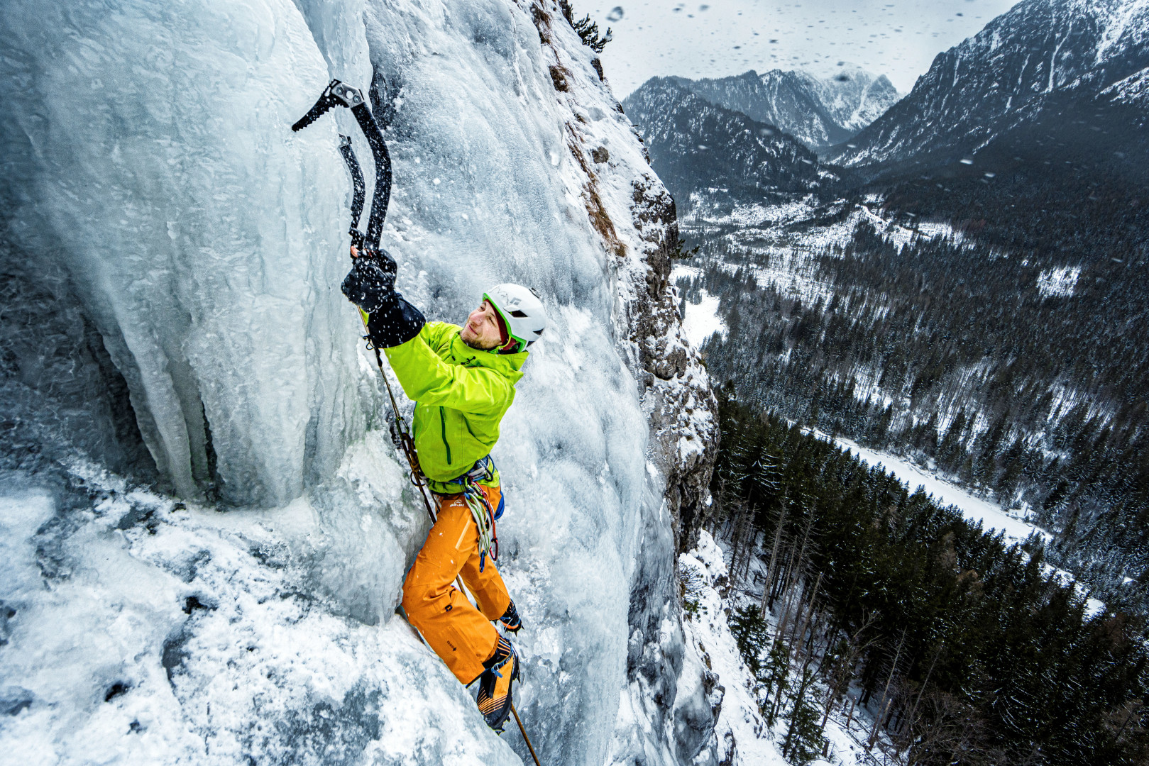 Man ice climbing up the Kaskady crag.